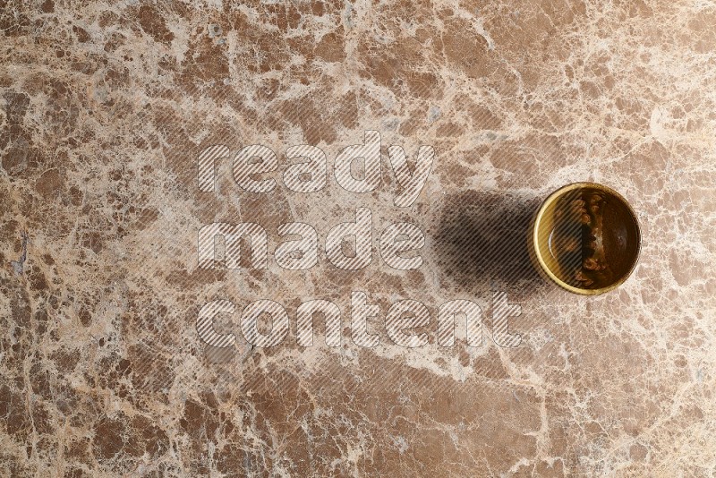 Top View Shot Of A Multicolored Pottery cup On beige Marble Flooring