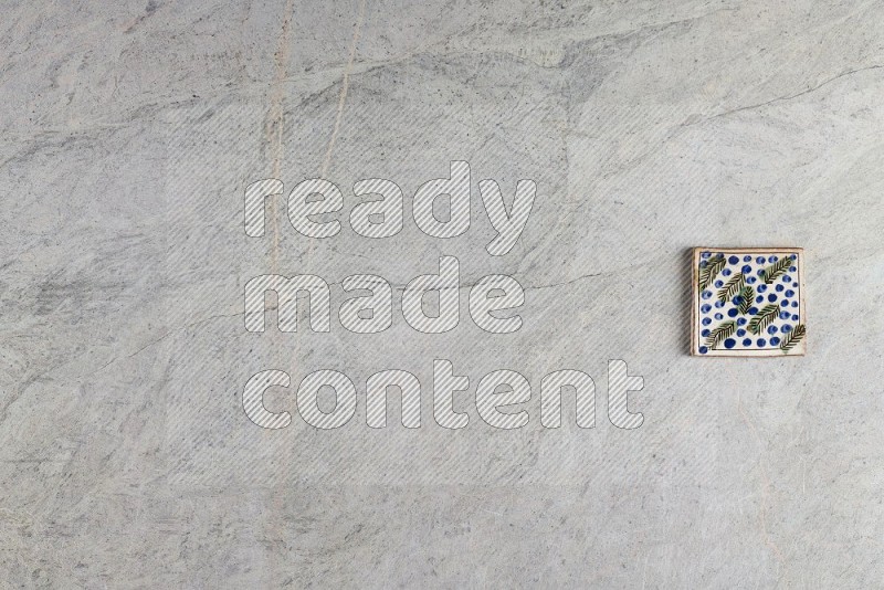 Top View Shot Of A Pottery Coaster tile On Grey Marble Flooring