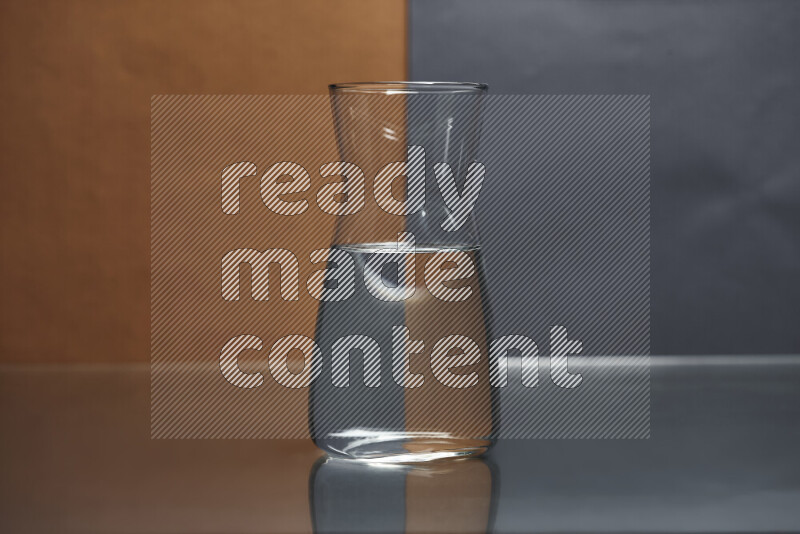 The image features a clear glassware filled with water, set against brown and dark blue background