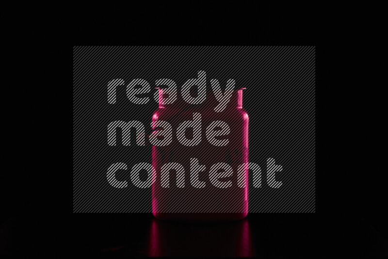 A vintage milk canister with colored rim light against black background