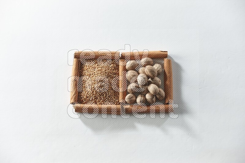 2 squares of cinnamon sticks full of mustard seeds and nutmegs on white flooring