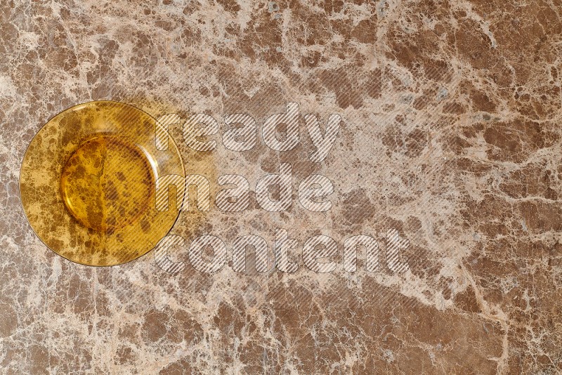 Top View Shot Of A Circular Glass Plate On beige Marble Flooring