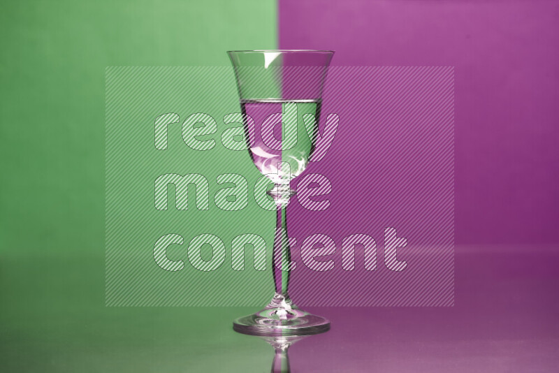 The image features a clear glassware filled with water, set against green and purple background