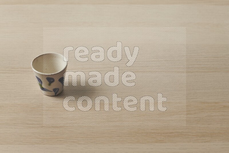 A pottery cup on light wooden background