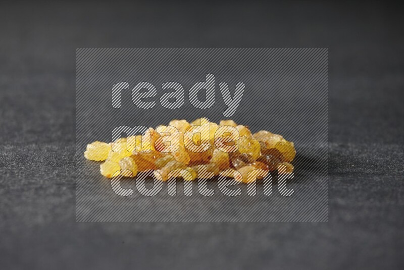 Yellow raisins isolated on a black background in different angles