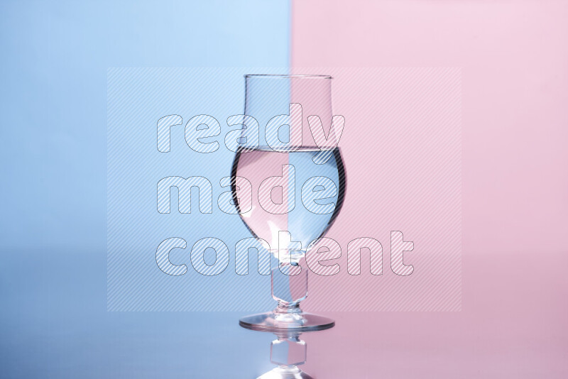 The image features a clear glassware filled with water, set against light blue and rose background