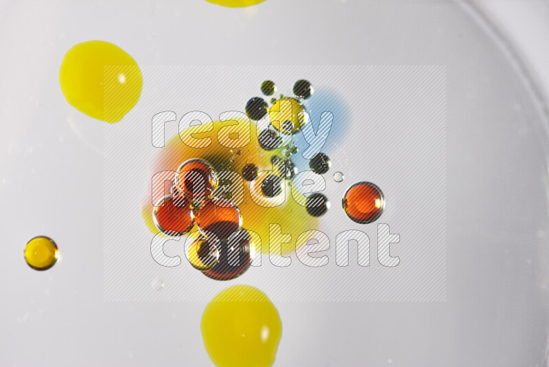 Close-ups of abstract red, blue and yellow watercolor drops on oil Surface on white background