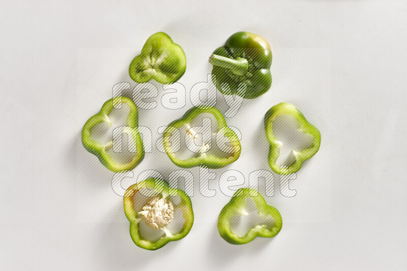 Green bell pepper slices on white background