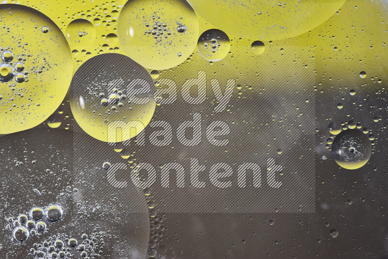 Close-ups of abstract oil bubbles on water surface in shades of yellow and brown