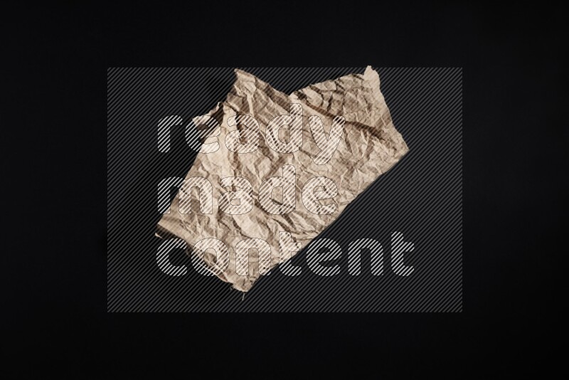 Crumpled craft paper on black background