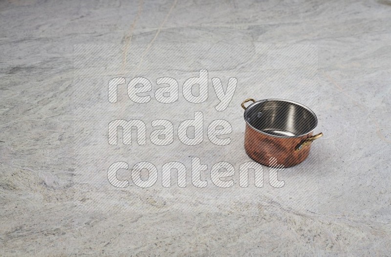 A Small Copper Pot On Grey Marble Flooring