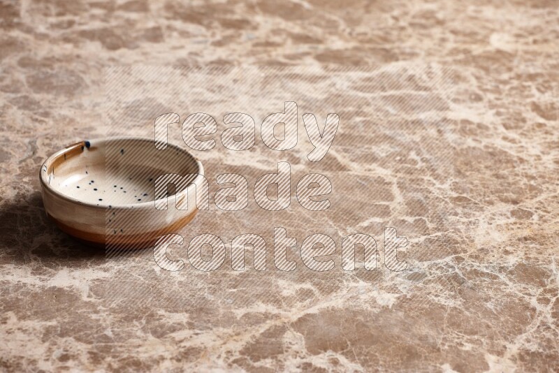 A multicolored pottery plate on beige marble background