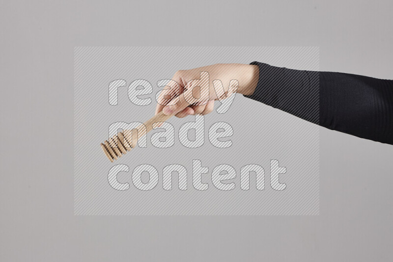 امرأة ترتدي عباءة سوداء تحمل أدوات خشبية مختلفة في أوضاع متعددة