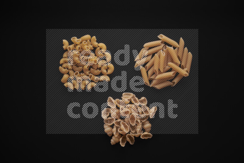 Different pasta types in bunches on black background