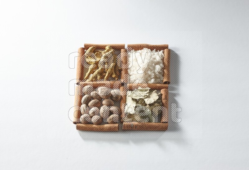 4 squares of cinnamon sticks full of salt, bay laurel, nutmeg, turmeric on white flooring