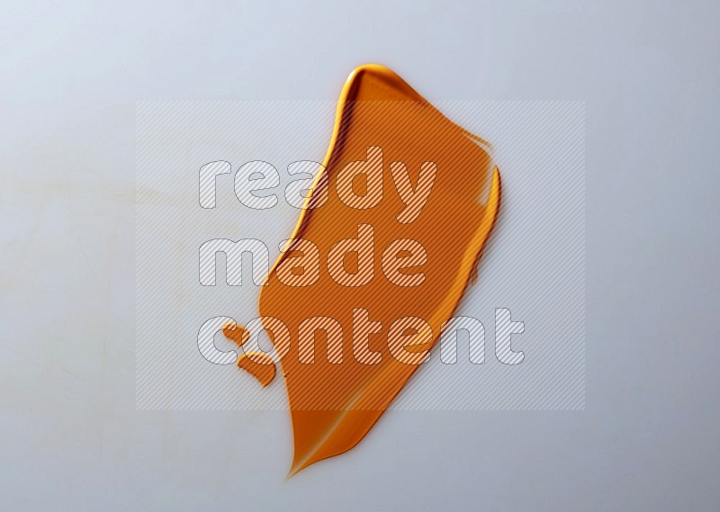 An orange single curved painting knife stroke on white background