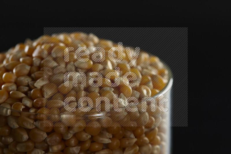 Pop corn in a glass jar on black background