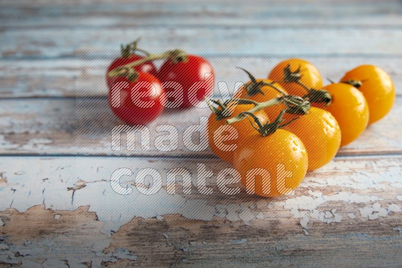 Mixed cherry tomato veins on a textured light blue wooden background 45 degree