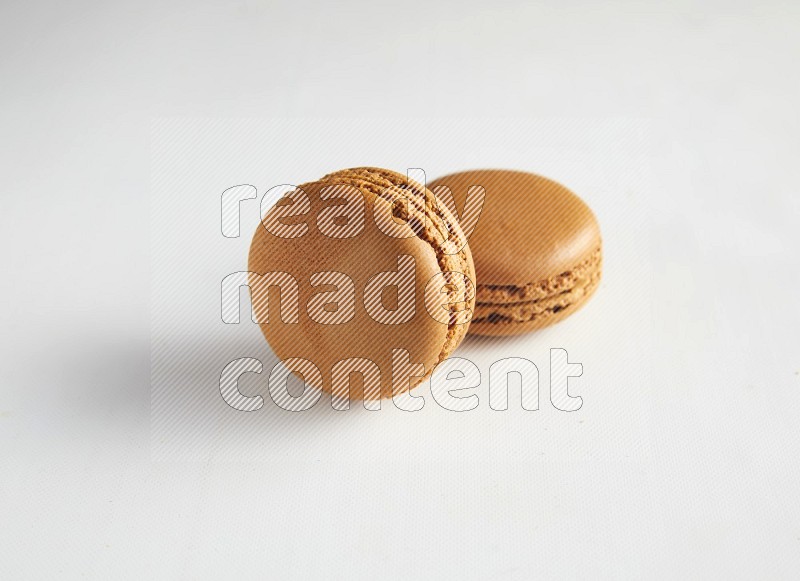 45º Shot of two Brown Maple Taffy macarons on white background