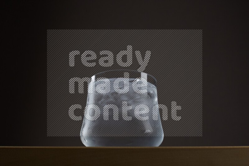 Low angle shot of a glass of water and ice on grey background