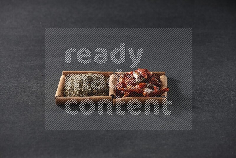 2 squares of cinnamon sticks full of chilis and cumin on black flooring