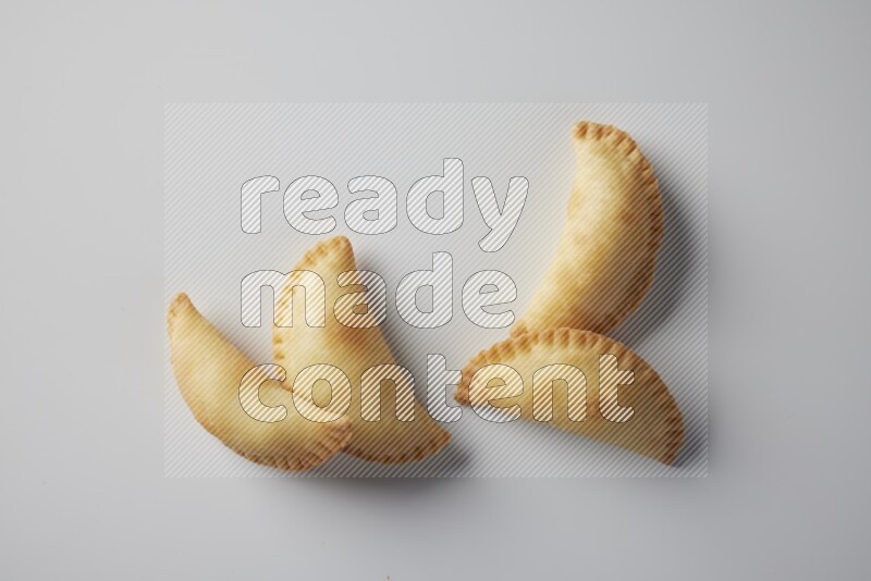 Four fried sambosa from a top angle on a white background