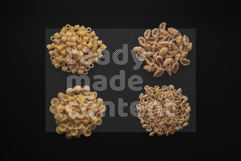 Different pasta types in bunches on black background