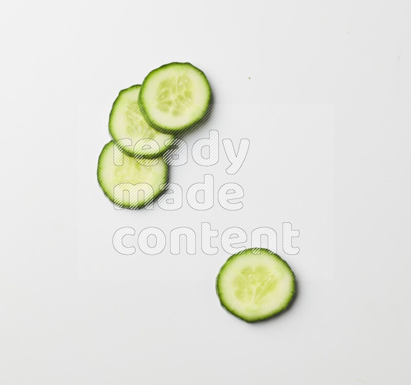 Multiple cucumber slices on white background
