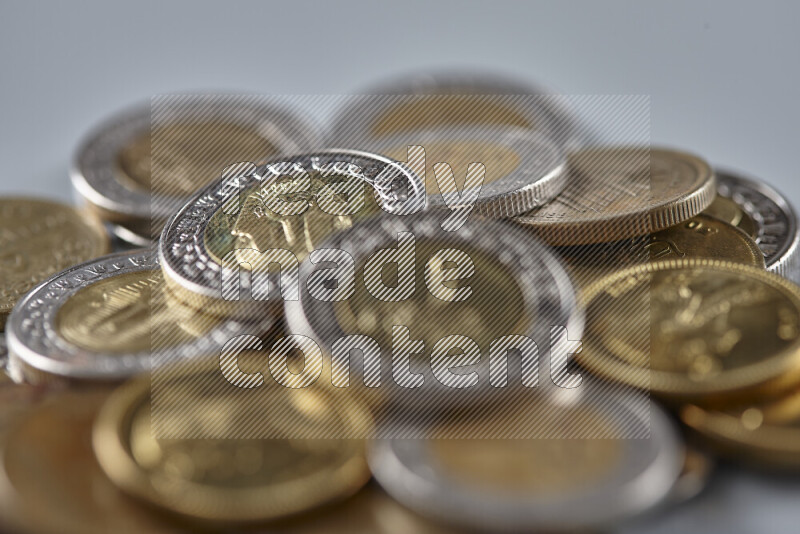 A close-up of scattered mixed Egyptian coins such as One pound, 50 and 25 piasters on grey background
