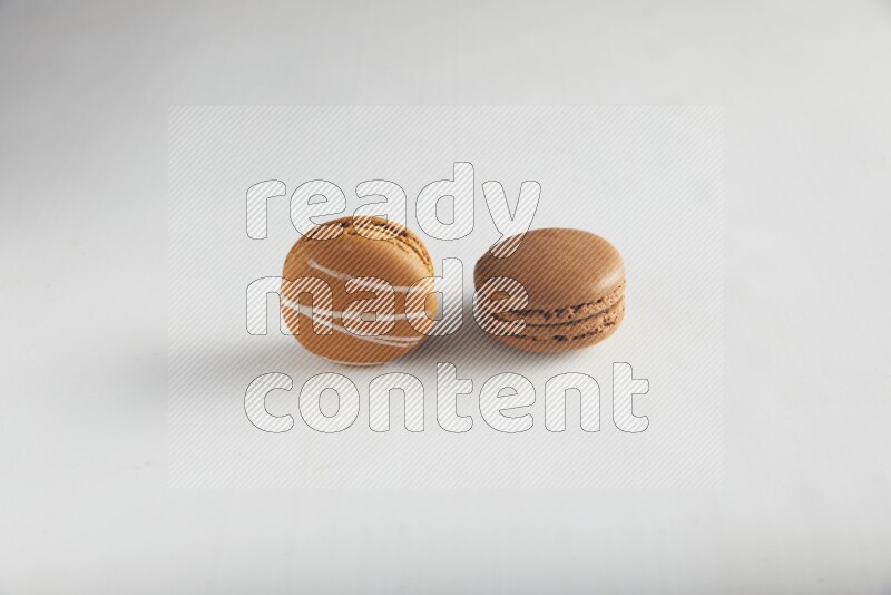45º Shot of of two assorted Brown Irish Cream, and Brown Coffee macarons  on white background