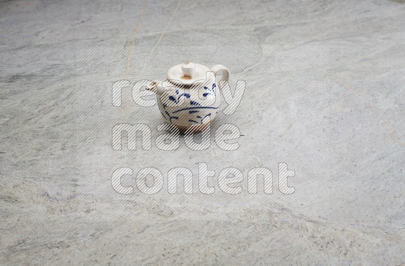 A Pottery Teapot On Grey Marble Flooring