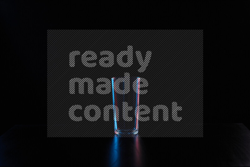 Glassware with rim light in red and blue against black background