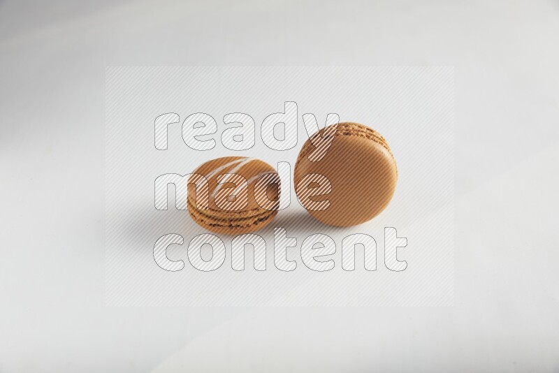 45º Shot of of two assorted Brown Irish Cream, and Brown Maple Taffy macarons  on white background