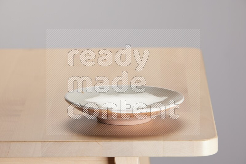 multi-colored pottery Plate on a wooden table edge