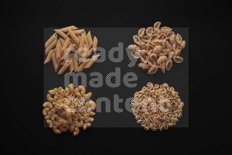 Different pasta types in bunches on black background