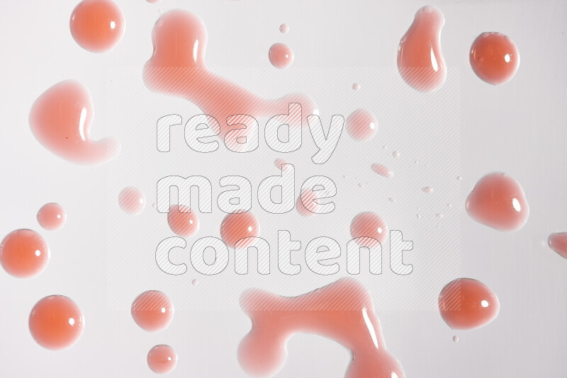 لقطات مقربة لقطرات من اللون الأحمر على خلفية بيضاء