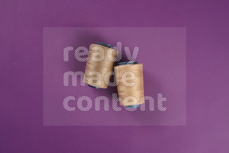 Beige sewing supplies on purple background