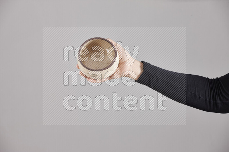 A woman in black abaya holding different pottery essentials in different positions