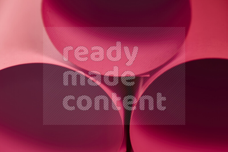 الصورة تعرض فن ورقي تجريدي بأشكال دائرية بدرجات متنوعة من اللون الأحمر