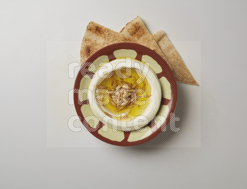Lebnah garnished with pine nuts in a traditional plate on a white background