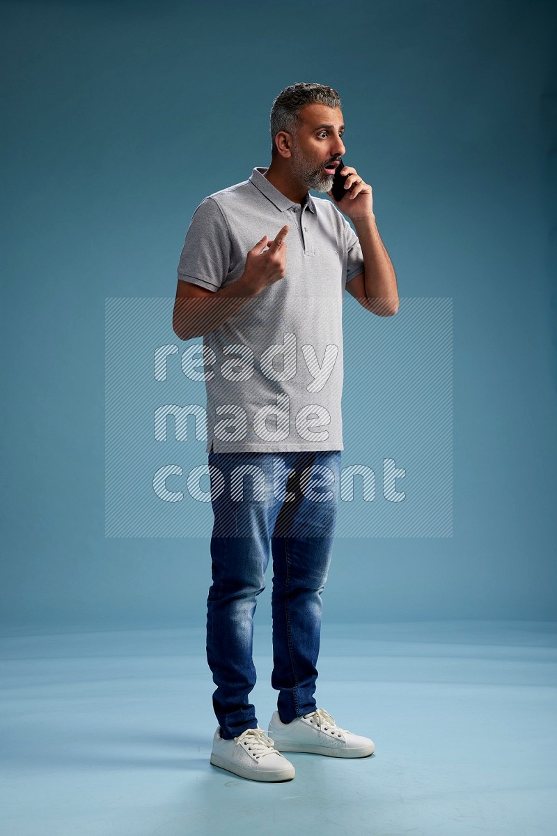 Man Standing talking on phone on blue background