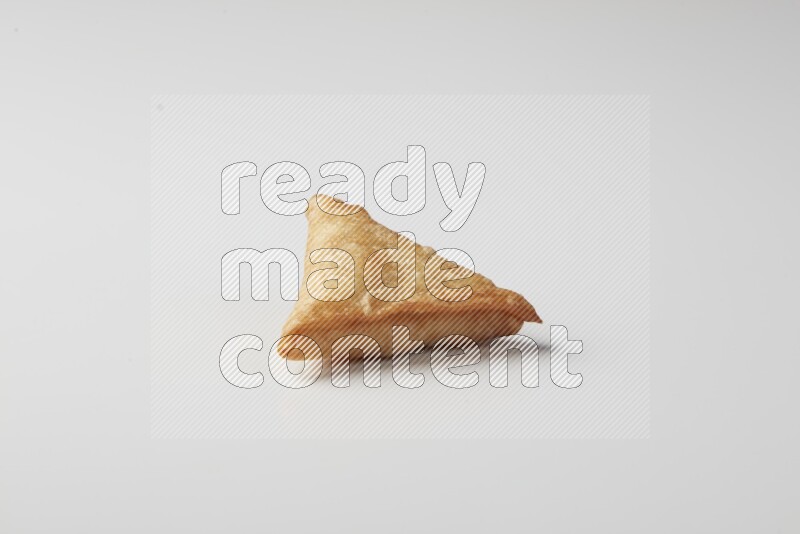 One fried sambosa on a white background
