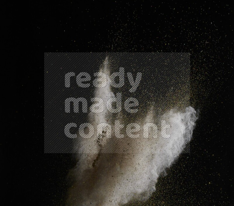 A side view of brown powder explosion on black background