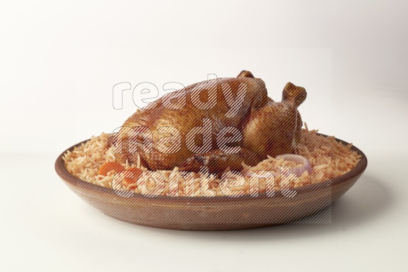 red basmati Rice with whole roasted chicken on a pottery plate direct on white background