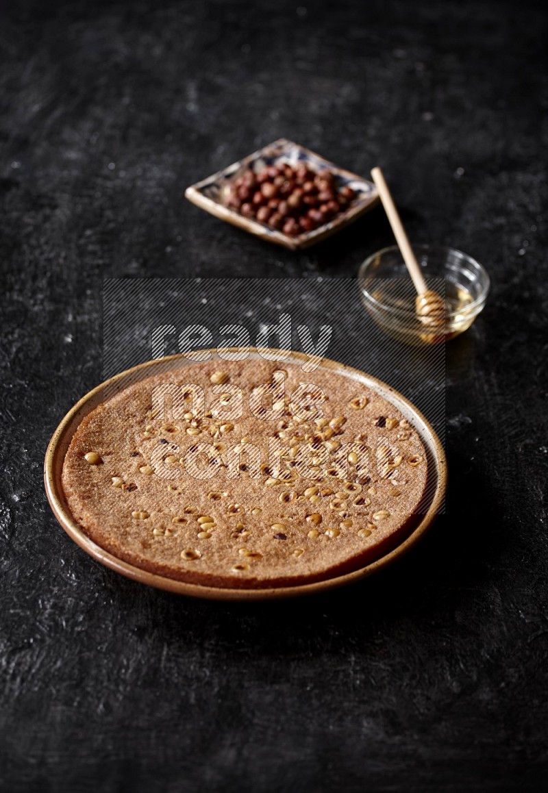 Basbousa with nuts and honey in a dark setup