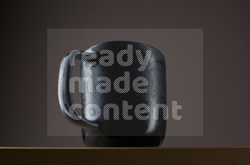 Low angle shot of a black cup on grey background