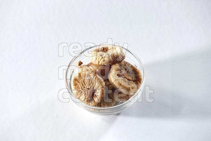 A glass bowl full of dried figs on a white background in different angles