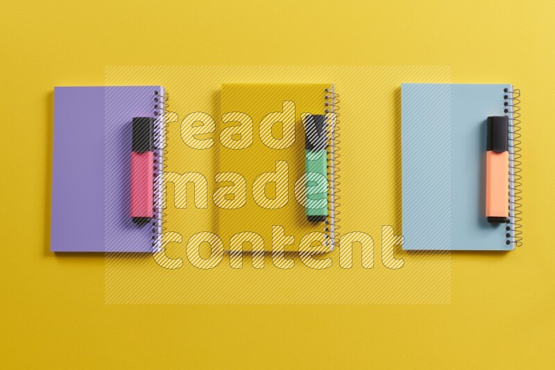 Multicolored notebooks with school supplies on yellow background