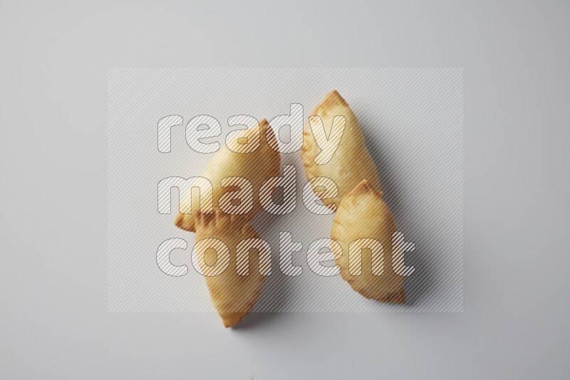 Four fried sambosa from a top angle on a white background