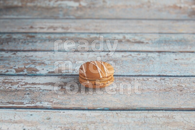 45º Shot of Brown Irish Cream macaron on light blue wooden background